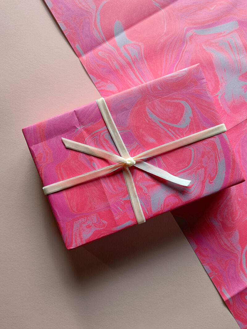 gift wrapped in pink marble effect wrapping paper with cream velvet ribbon tie and bow