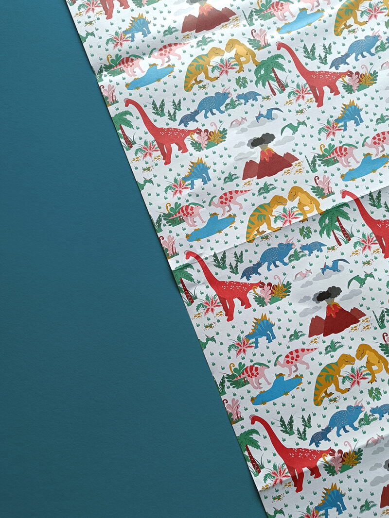 illustrated dinosaur wrapping paper with t-rex, parasaurolophus, brachiosaurus, triceratops, stegosaurus and volcanoes.