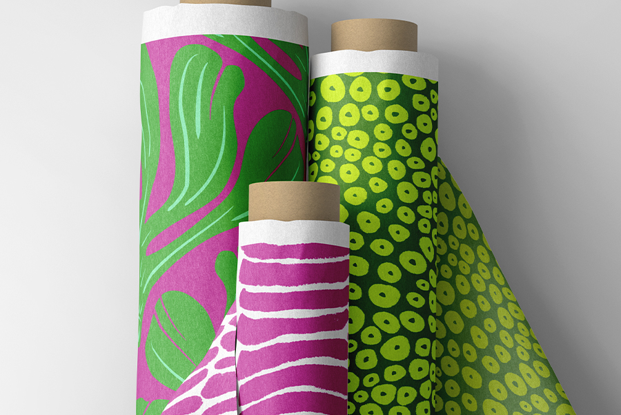 Fabric rolls of Curious Kin's neon fossils pattern collection including abstract stripe, polka dot and ginkgo leaf patterns in magentas and greens.