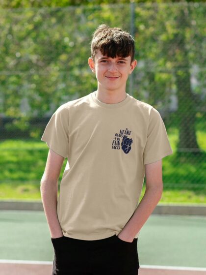 Young boy wearing Curious Kin's my heart beats in fun facts design printed on oat coloured t-shirt.