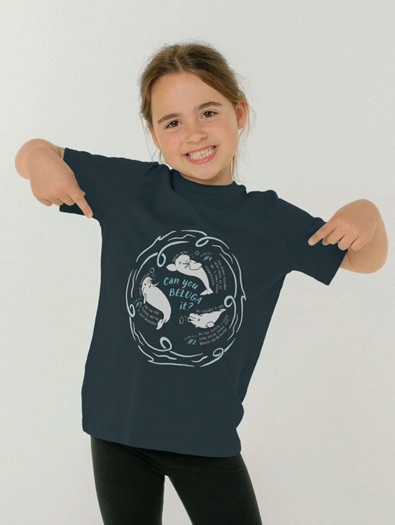 Child pointing to their top with Curious Kin's what a beluga design printed on it