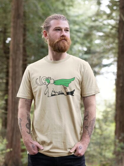 Man stood in woods wearing an oat coloured t-shirt with Curious Kin's superhero mammoth design printed on it