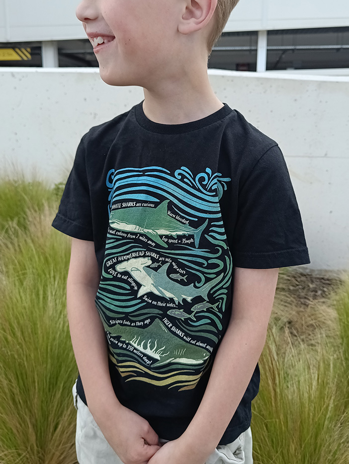 boy smiling wearing shark tshirt