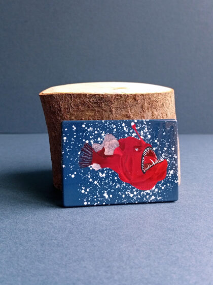 Rectangular illustrated sea devil angler fish magnet made from recycled plastic.