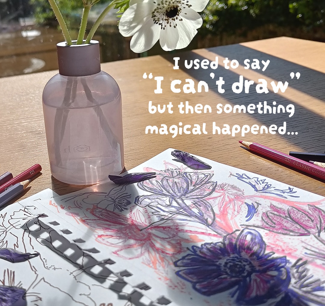 Table with anemones in purple vase with sketches of anemone flowers and pencils on table.