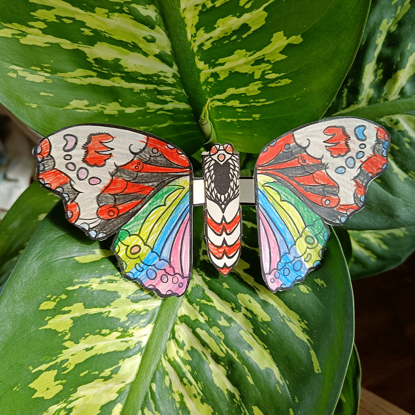 Paper craft flutter butterfly sitting on green leaves