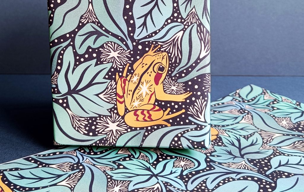 Gift wrapped in alaskan wood frog and frosted leaf litter luxury gift wrap and sheet of gift wrap cropped