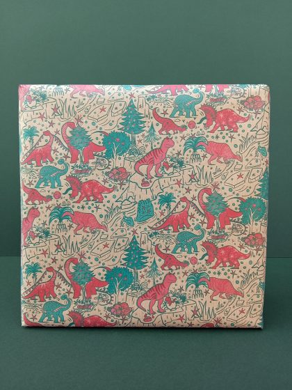 Gift wrapped in recycled paper with a hand-draw Christmas dinosaur seamless pattern in red and green tones.