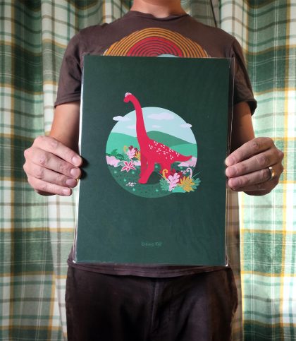 Bright and bold illustration of a red brachiosaurus on an evergreen background hung on magnetic hanger.