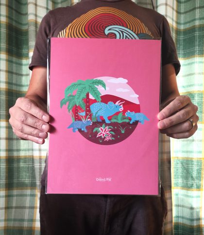 Bright and bold illustration of a blue triceratops family under a palm tree and surrounded by prehistoric plants on a soft pink background.