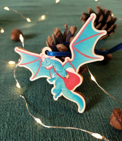 A wooden decoration with ribbon tie of a Christmas dragon with a bag full of stars