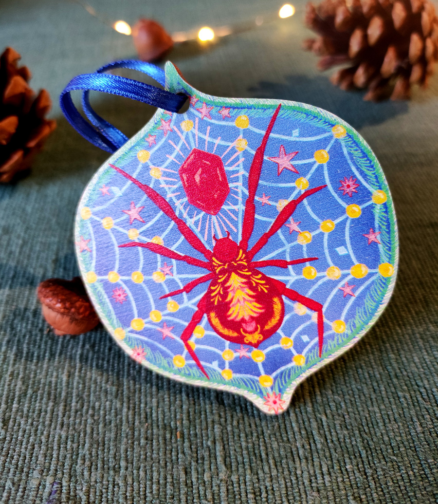A Christmas spider wooden tree decoration with ribbon tie in red and blue.