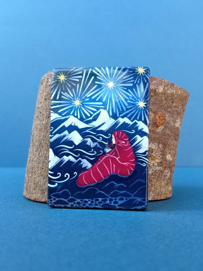 Rectangular magnet leaning against wood offcut featuring illustration from Sky dreamer, mountain explorer print.