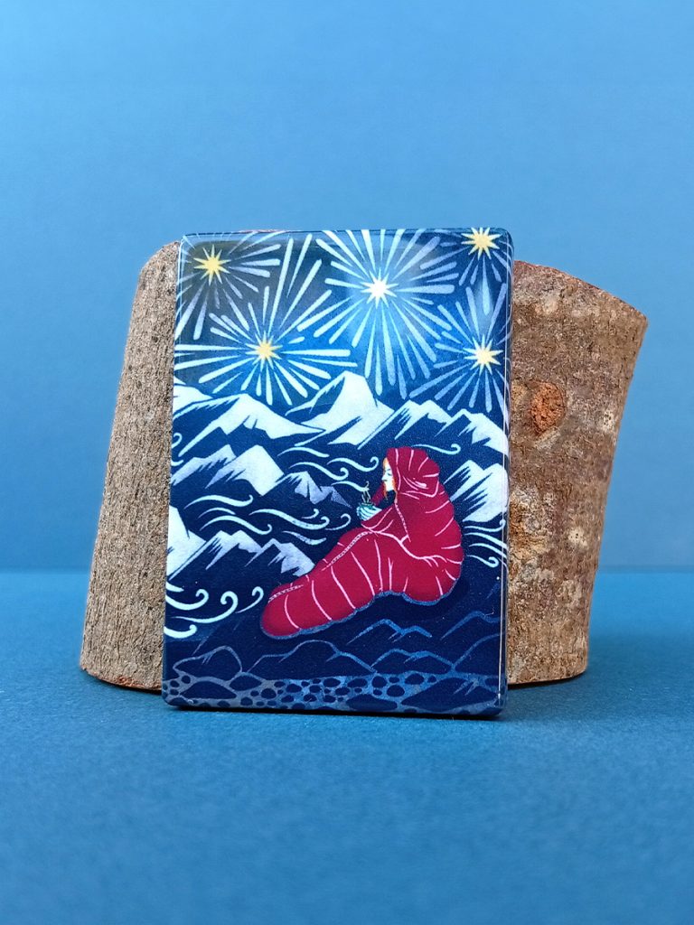 Rectangular magnet leaning against wood offcut featuring illustration from Sky dreamer, mountain explorer print.