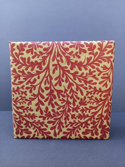 Gift wrapped in recycled wrapping paper with seamless hand-drawn seaweed pattern in red