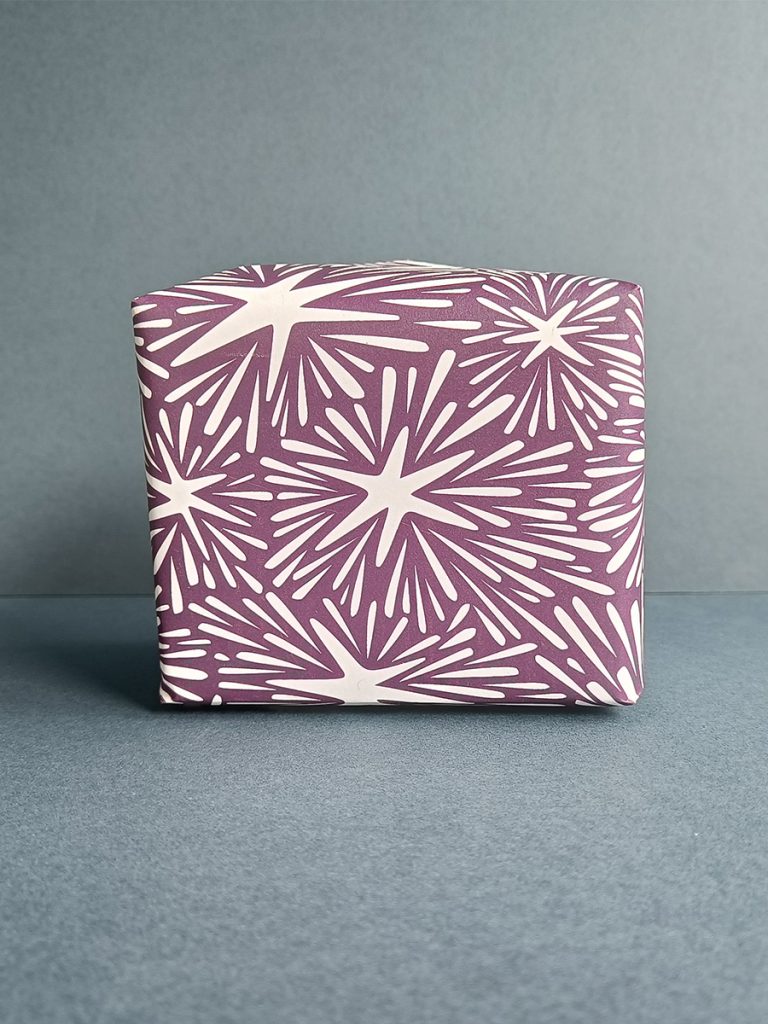 Gift wrapped in Stars and light rays in deep purple luxury gift wrap