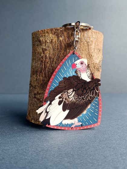 White headed vulture keyring on a shield background in blue and red.