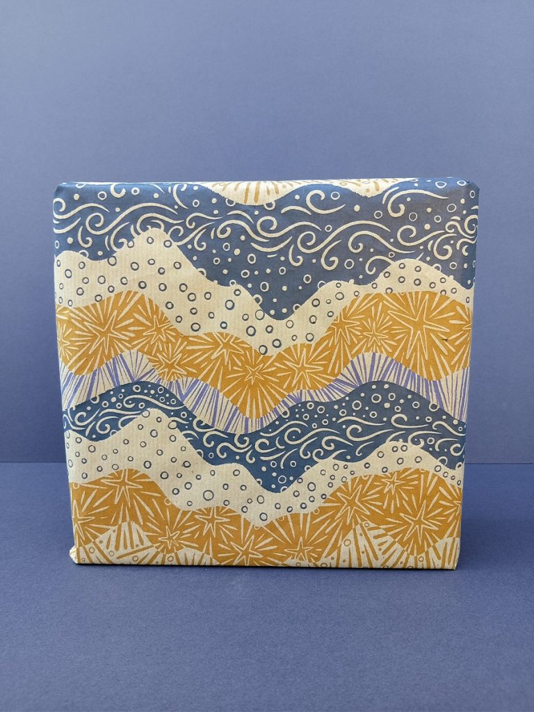 Gift wrapped in mountains of starlight and cloud scape in blue, purple and gold tones.