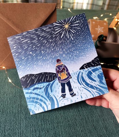 Illustration of a female explorer walking through snow storm with star above printed on square card.